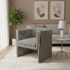 A modern striped armchair with a slatted frame, styled in a contemporary living room setting with a light-colored rug, side table, and neutral-toned sofa.